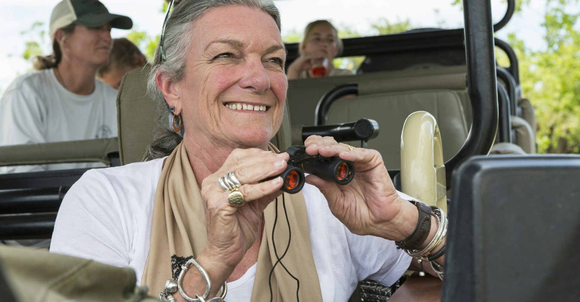 a-family-in-a-safari-jeep-in-a-wildlife-reserve-a-seniorwoman-with-binoculars-.jpg