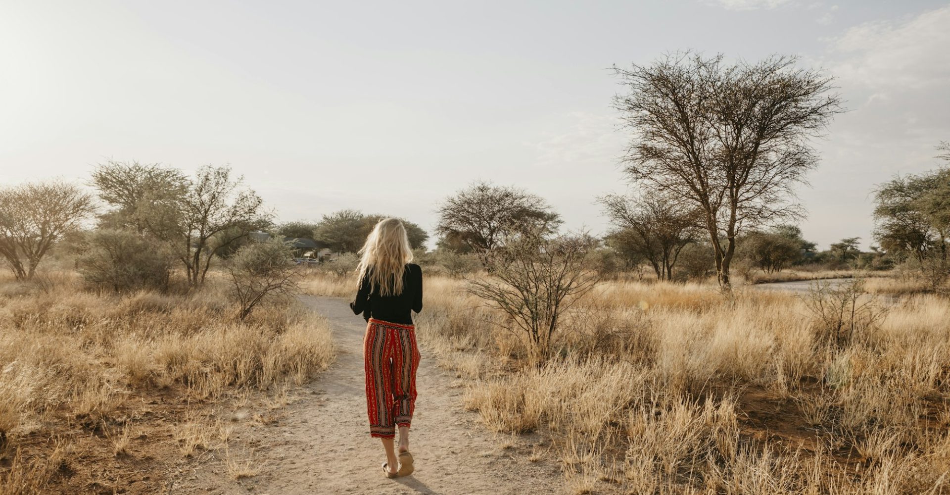 africa-namibia-blonde-woman-walking-on-way-in-grassland.jpg