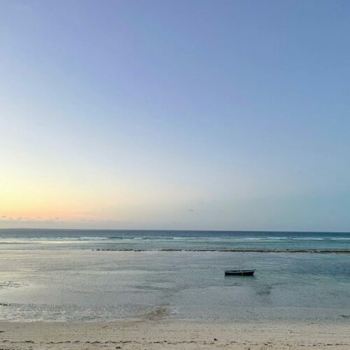 Rustic boat lay on the beach at low tide at dusk in northern Mozambique